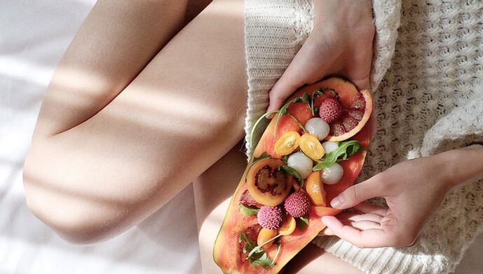 Girl with papaya and other fruits.